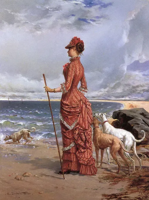 elegant lady walking her greyhounds on the beach